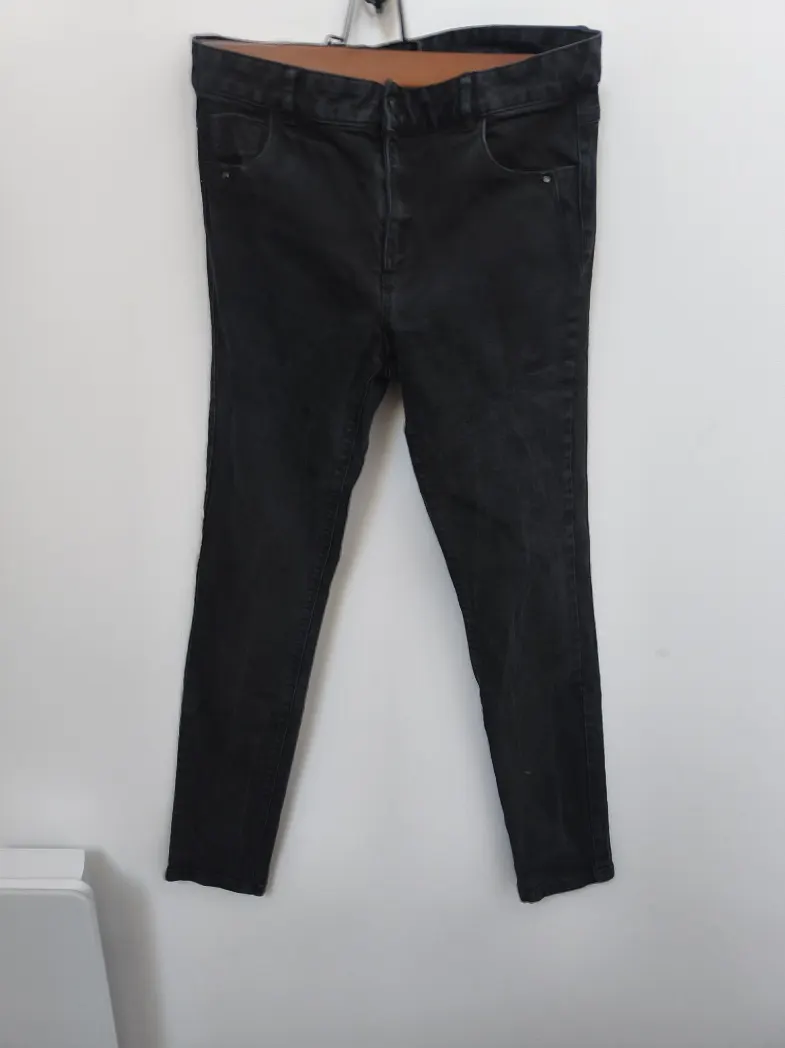 Photo d'un jean noir large coupe regular en boule sur une étagère