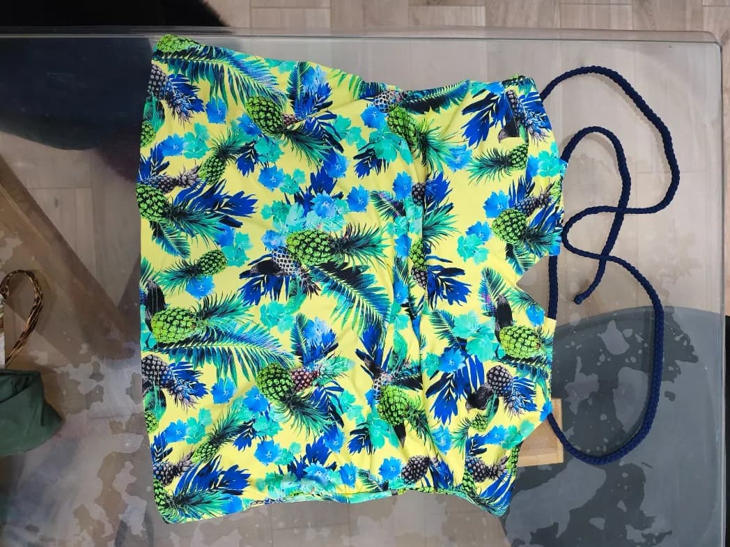 Photo d'un maillot coloré vert et tropical léger posé sur un canapé