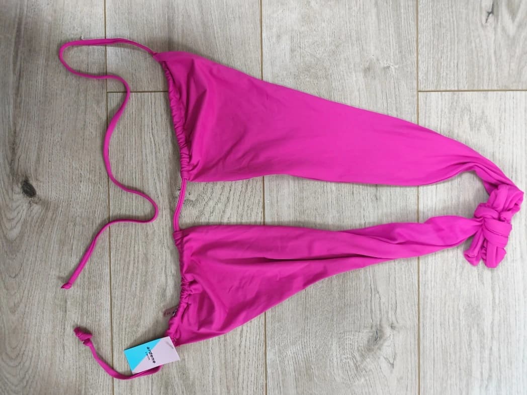 Photo d'un soutien gorge atypique rose au sol avec un éclairage médiocre