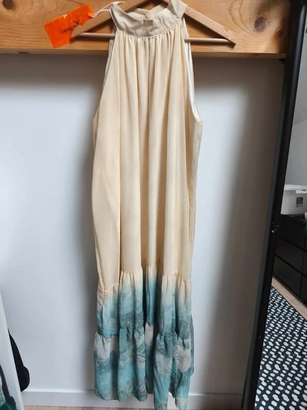 Photo d'une robe longue à dégradé blanc vers bleu pliée sur une table