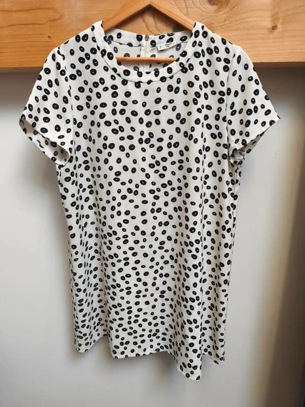 Photo d'un t-shirt dalmatien à petits points noirs dans un carton de livraison