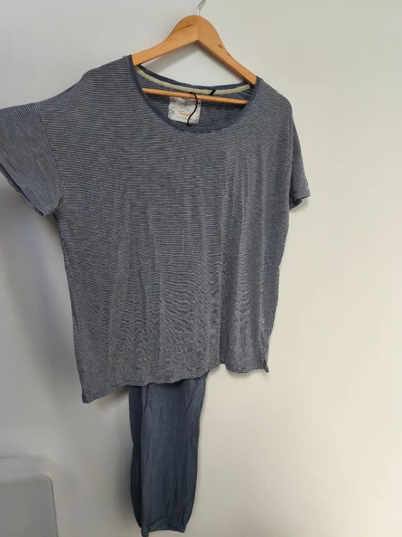 Photo d'un ensemble de pyjama t-shirt et pantalon rayé étalé sur du parquet